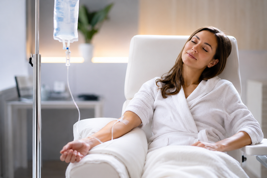 Woman relaxing in a robe while receiving NAD+ IV therapy in a Louisville wellness lounge