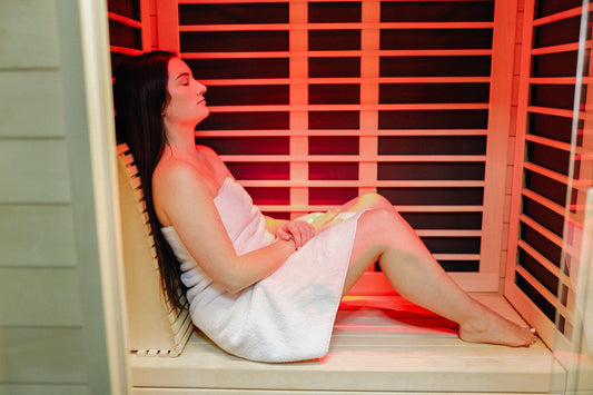 Person relaxing inside a modern infrared sauna cabin